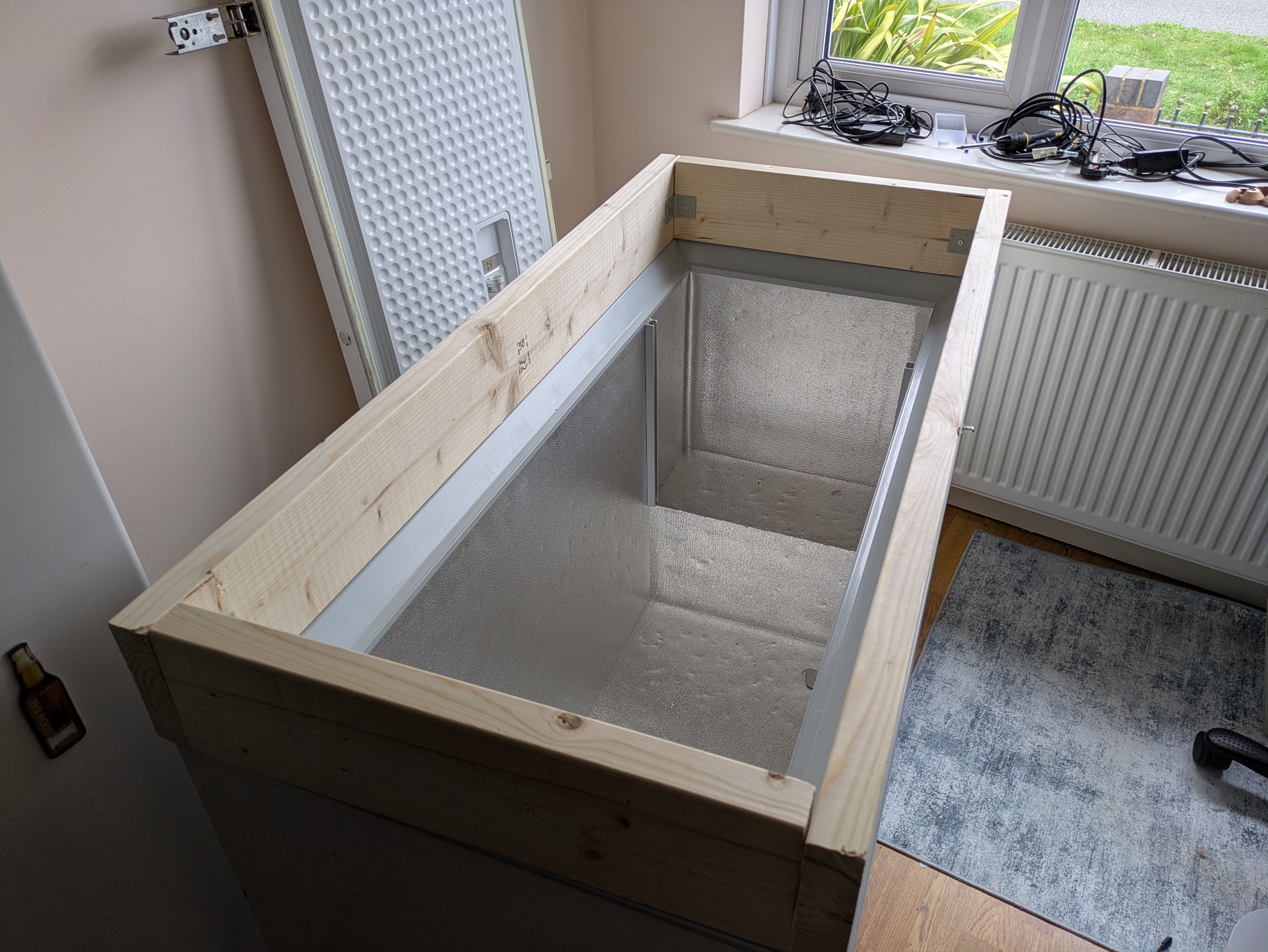 A wooden "collar", sitting on top of the body of the freezer